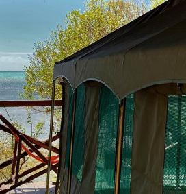 Tente hébergement de l'hotel Babaomby à Madagascar avec une terrasse et une vue sur une eau turquoise et de la végétation 