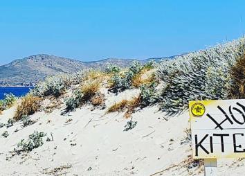 Plage et spot en Grèce à Kos avec un sable blanc, une eau turquoise flat, et une entrée du spot de kitesurf avec des montagnes
