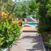 Couloir de l'hotel Urla Surf House en Turquie qui mène à la piscine avec de la végétation et des fleurs autour