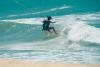 Kitesurfeur qui prend un virage serré sur la lèvre d'une vague sur le spot de Taïba au Brésil