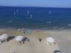 Quelques pratiquants naviguent en windsurf devant le centre big Blue à Kos