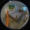 Chambre fisheye de l'hotel Urla Surf House en Turquie avec un lit double en bois et un hamac