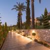 Jardin de l'hôtel Horizon Beach Resort à Kos en Grèce, durant la nuit avec des palmiers, des fleurs, des arbres et une allée éclairée