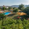 Vue aerienne de la piscine et l'espace chill avec des transats et parasols de l'hotel Urla Surf House entouré de végétation et palmiers