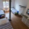 Chambre de kite avec trois lits simples et des planches de kite accrochées au mur