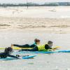 Cours de surf au spot Lassarga avec ION Club avec des enfants sur la planche dans la lagune et des dunes de sables du désert