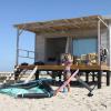 Paula, rideuse, qui se prépare pour une session wingfoil avec du matériel Duotone devant les bungalows et sur le sable du désert du Sahara à Dakhla Lassarga
