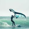 Rideur qui fait du wingsurf sur le spot de Dakhla Lassarga avec des vagues, une eau bleue turquoise et du matériel Duotone