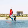 Cours de windsurf sur le spot flat de Dakhla Lassarga avec du matériel Duotone de ION Club devant les bungalows et sur une eau bleue claire