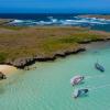 Deux windsurfeurs en action sur l'eau turquoise flat du spot Madagascar devant une île