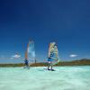 Deux windsurfeurs en train de naviguer sur le spot flat de Madagascar sur le lagon avec une eau turquoise et transparente