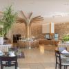 Restaurant en bois et pierre de l'hôtel Horizon Beach Resort à Kos en Grèce avec buffet, tables, et plantes