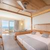 Chambre double de l'hôtel Horizon Beach Resort avec une terrasse vue sur la mer, deux lits deux places et du bois à Kos en Grèce