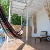 Espace chill dehors de l'hotel Urla Surf House avec un hamac au soleil et des canapés à l'ombre