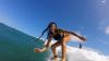 Surfeuse souriante sur la vague sur le spot de Saint martin aux Antilles