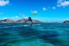 Un kitesurfeur et un windsurfeur sont en navigation sur le spot de Saint Martin aux Antilles